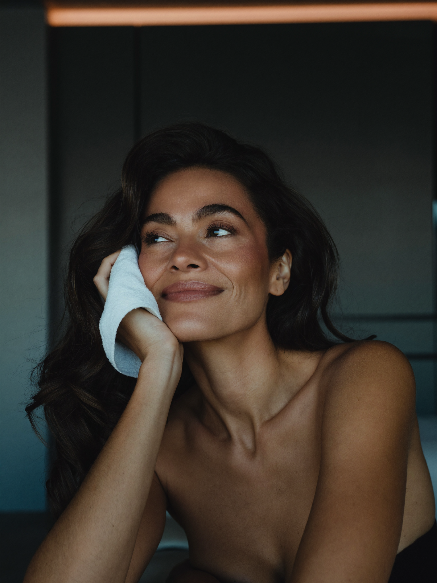 A naturally refreshed woman in soft natural light — look like yourself, only rested