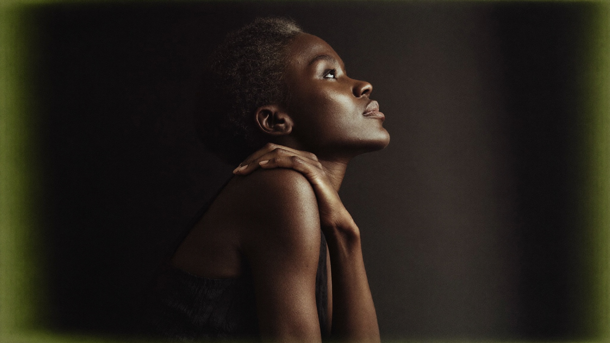 A confident woman in her late forties in profile, chin lifted, in dramatic editorial light