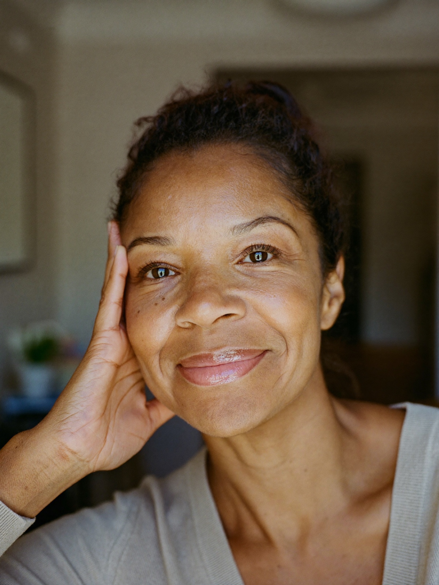 A relaxed woman in her mid fifties at home in soft daylight, looking rested and refreshed