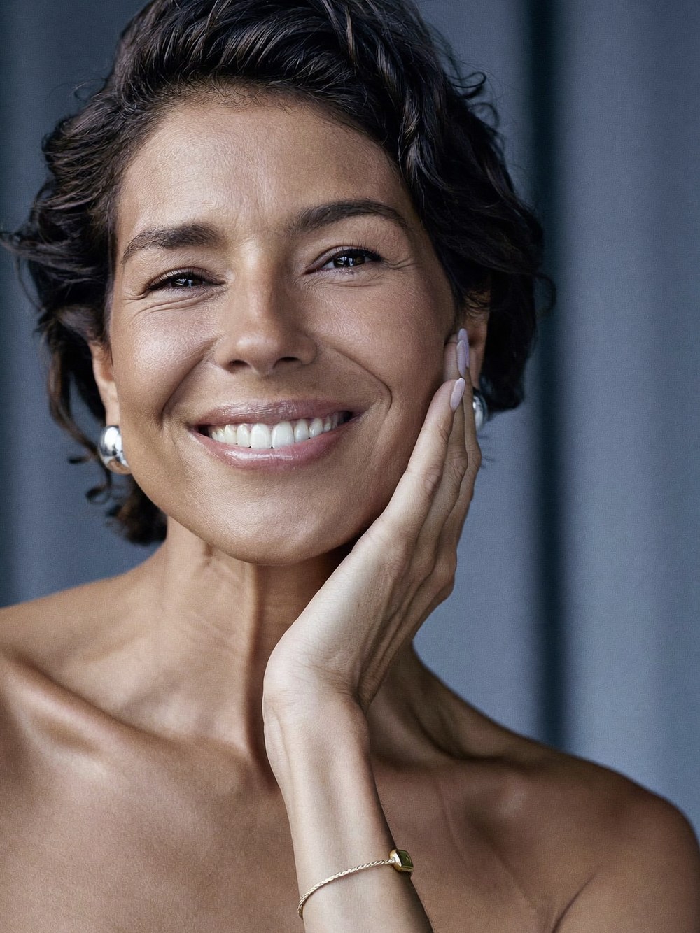 A poised, naturally refreshed woman in her fifties looking rested and confident